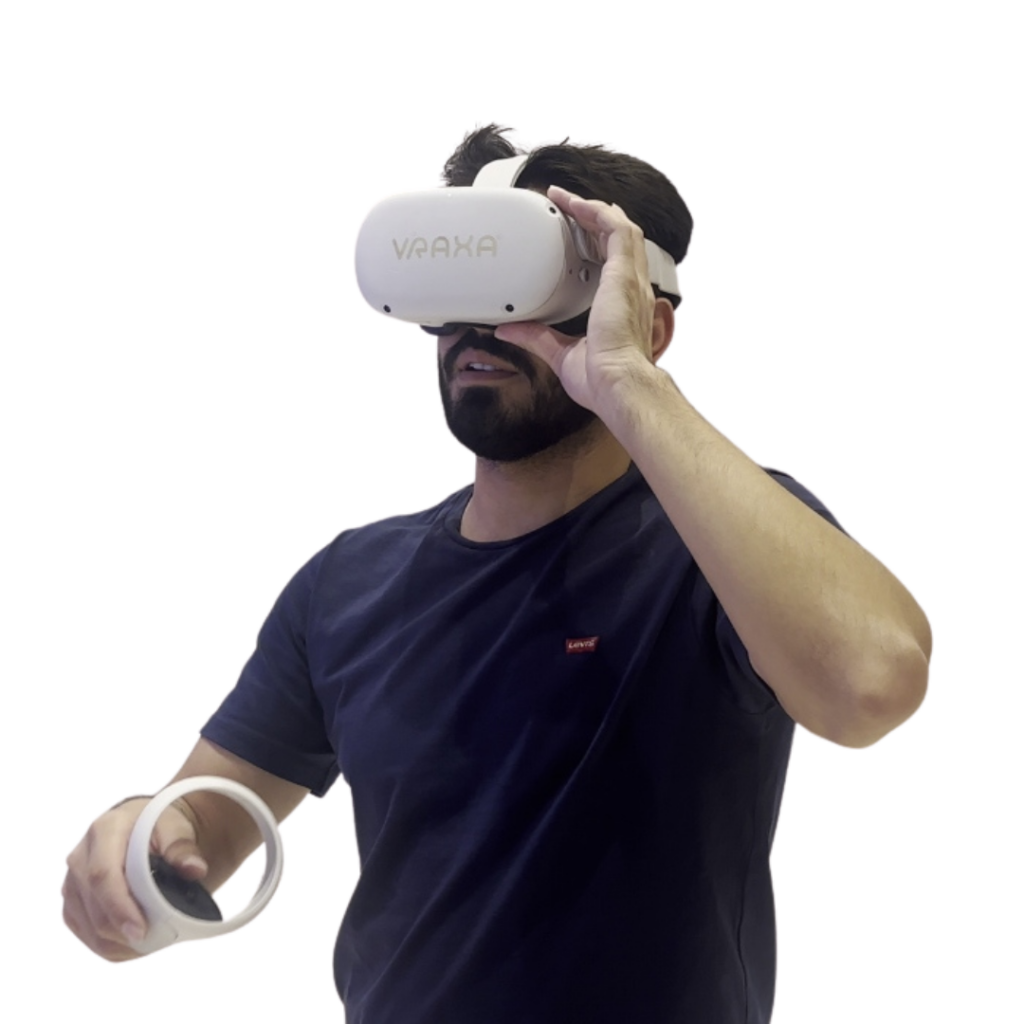 A person wearing a shirt with a logo is immersed in Vraxa services using a VR headset labeled VRAXA and holding a controller.