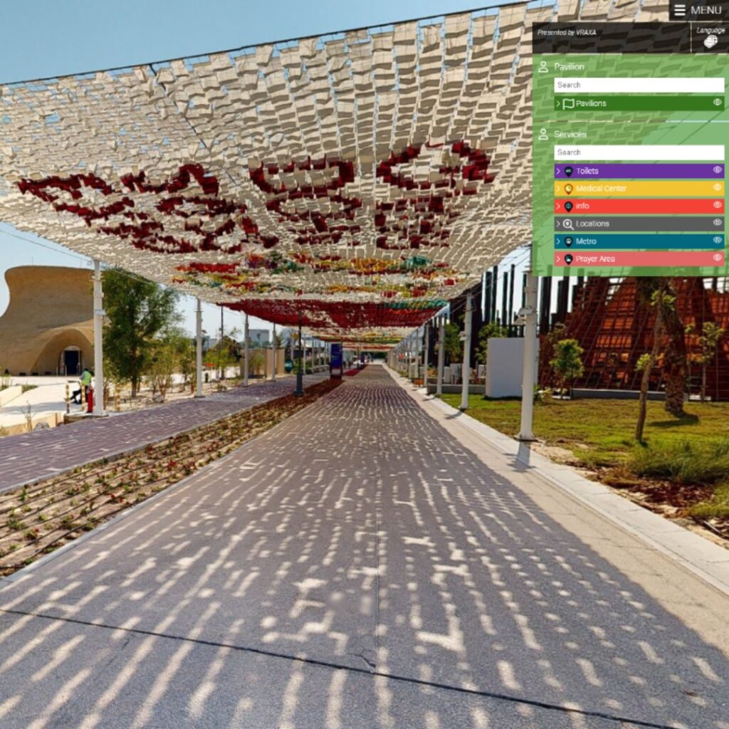 A preview of virtual experience showing a shaded pathway with colorful knitted canopy overhead in a park setting. A path runs through, flanked by plants and trees. A side menu showing some services available in the area.