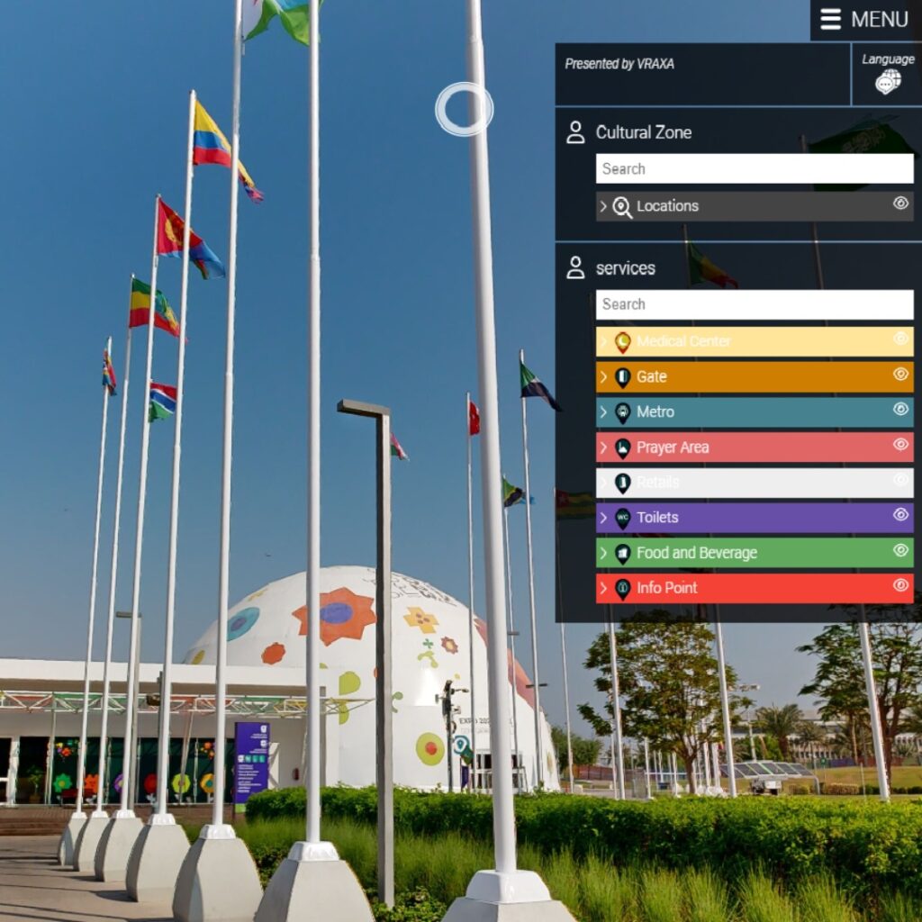 A preview of virtual experience showing a modern building with a dome shape, decorated with colorful designs, surrounded by flagpoles with various flags. A large menu displays different services like a medical center, metro, and food and beverage.