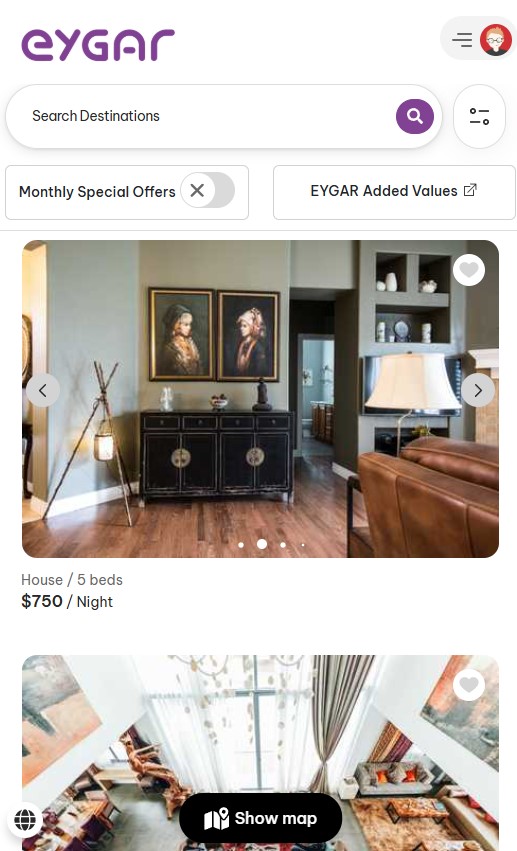 Eygar website page , part of the Vraxa subsidiaries, shows listings for rental homes. The first listing features a living room with paintings, a console, and a lamp. Options for monthly offers and added values are clearly visible at the top.