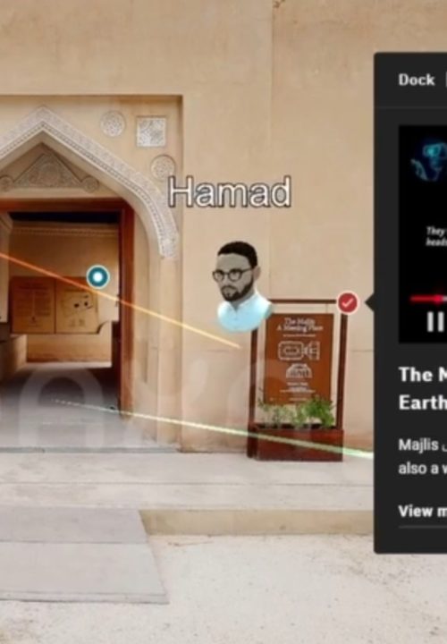 A virtual tour interface of a historical building entrance. A 3D map with an avatar head and text is shown on the screen.